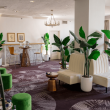 AFR Wellness Lounge white couches green stools and plants in white pots
